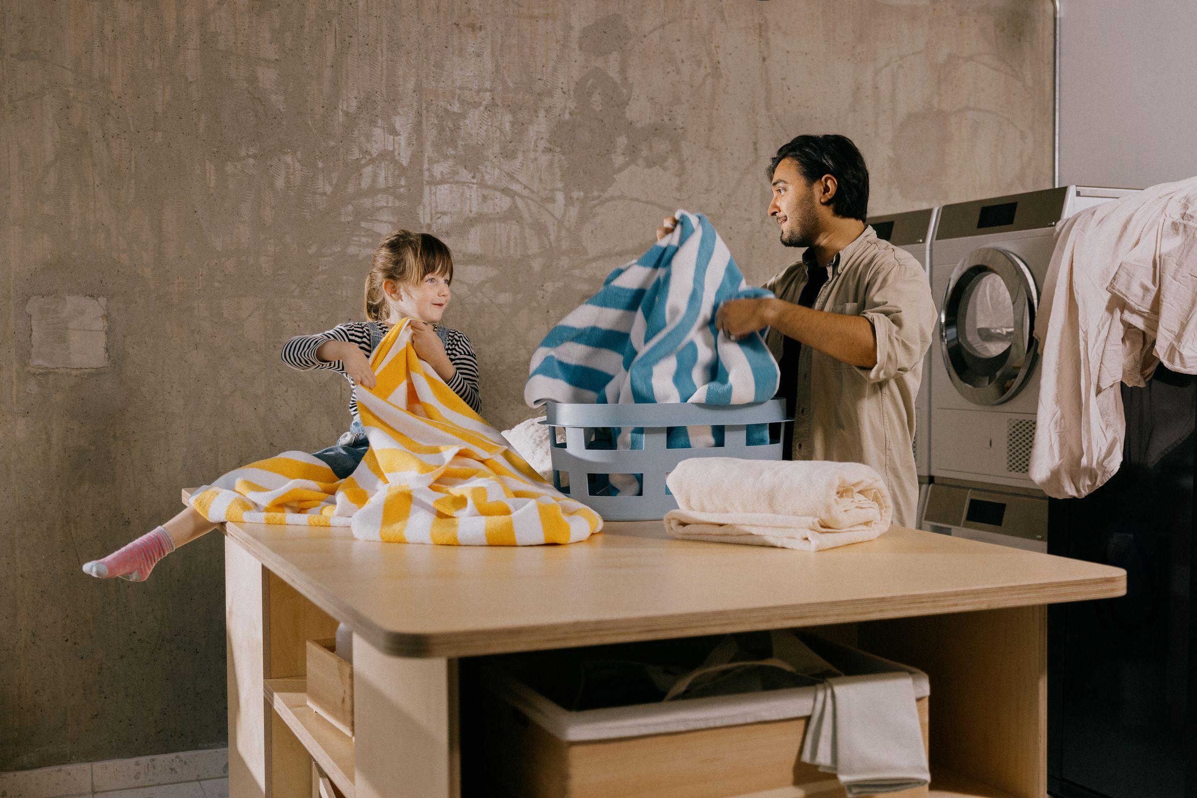 Mann og barn vasker klær i fellesvaskeriet i OBOS Living Lab