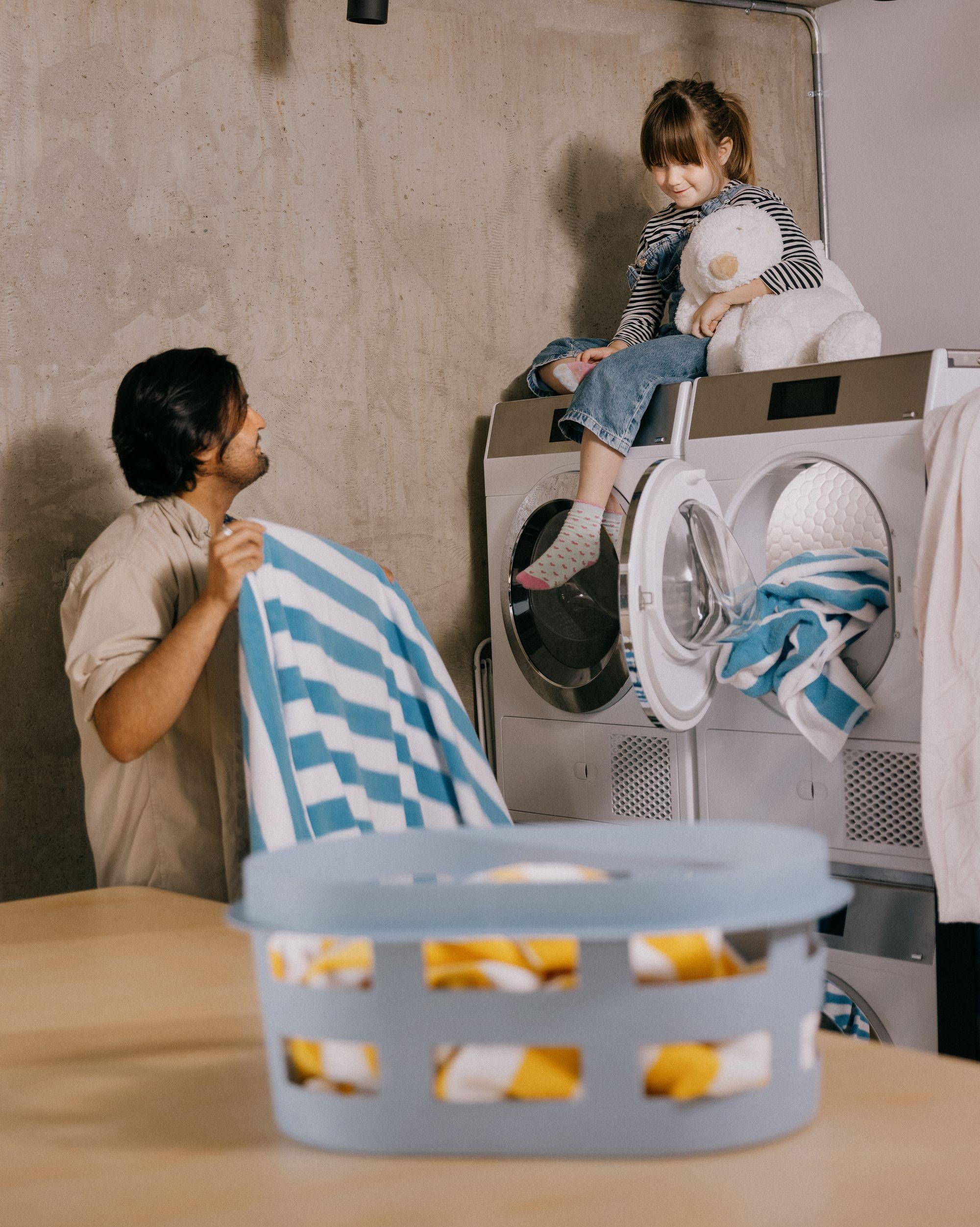 Foto av et barn og en mann som tar ut av en vaskemaskin i OBOS Living Lab.